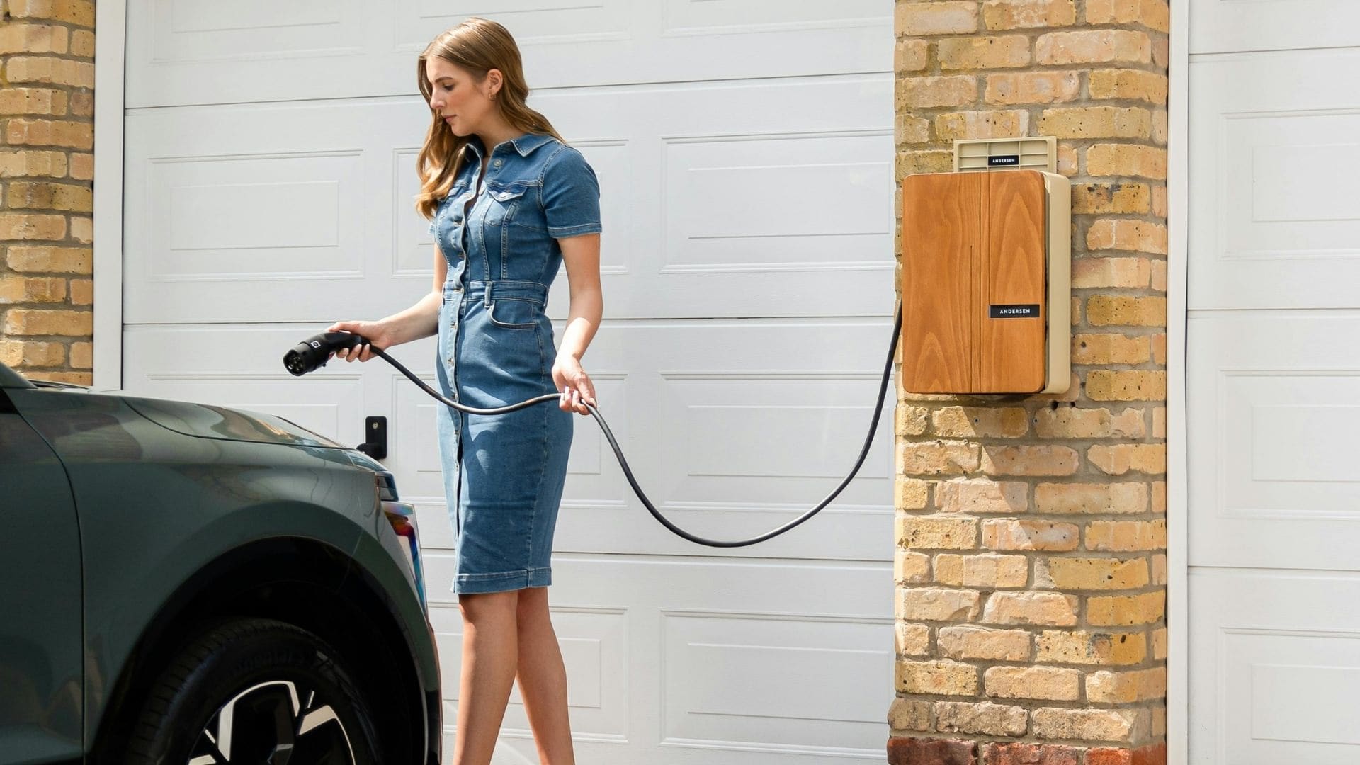 Homeowner plugging an EV charging cable in at home in southern New Hampshire