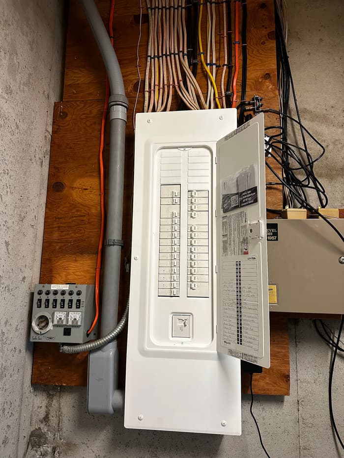 A new basement load center paired with a generator transfer switch and neatly dressed home runs.