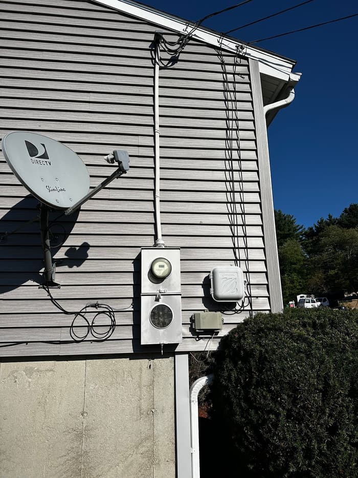 Meter socket and service equipment mounted and sealed on the side of a home.