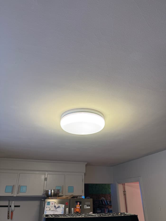 An LED flush-mount fixture replacing a dated kitchen ceiling light.