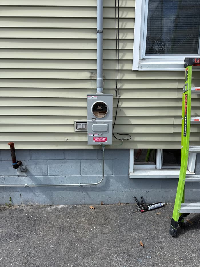 A replacement meter socket with new service conductors run down to the panel.