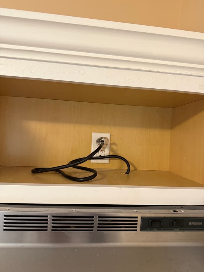 A dedicated outlet installed inside the upper cabinet to feed an over-the-range microwave.