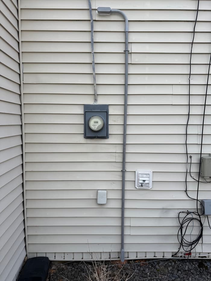 Service mast, meter, and exterior devices tied together on a residential service upgrade.