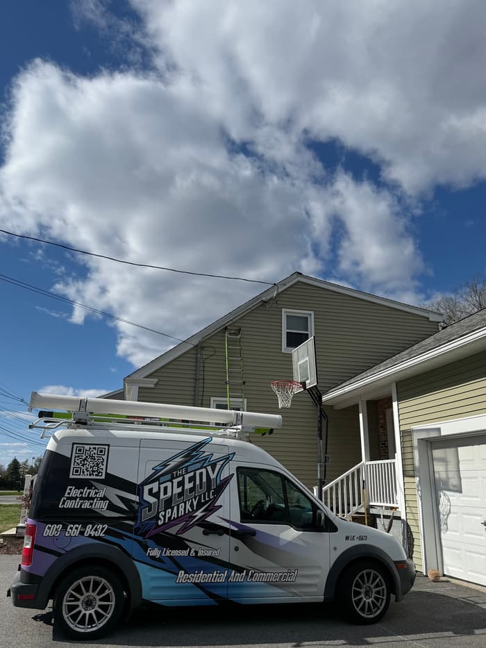 The van set up outside a home for an exterior lighting and wiring job.