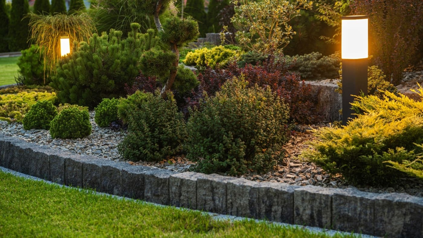 Garden post lights illuminating plants and walkways at dusk