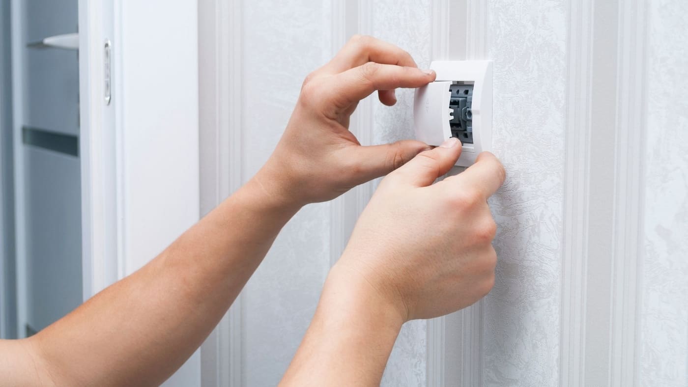 Electrician installing a GFCI outlet in a residential wall