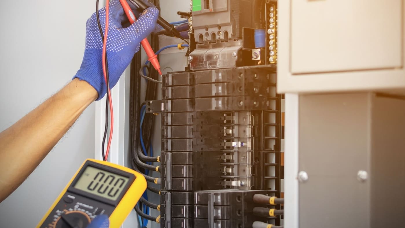 Electrician troubleshooting a residential breaker panel in a New Hampshire home