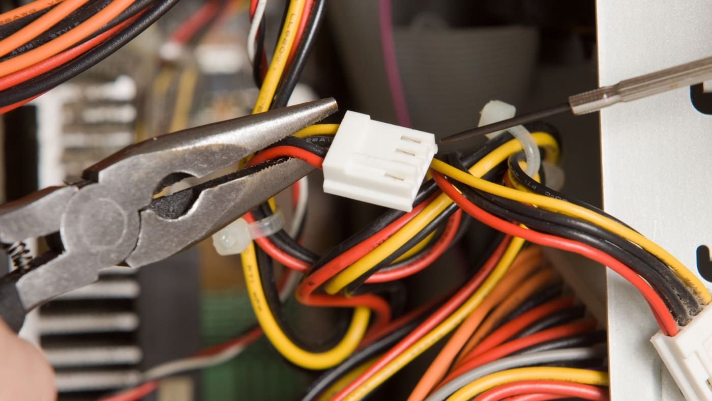 Close-up of an electrician securing a wire connector with pliers